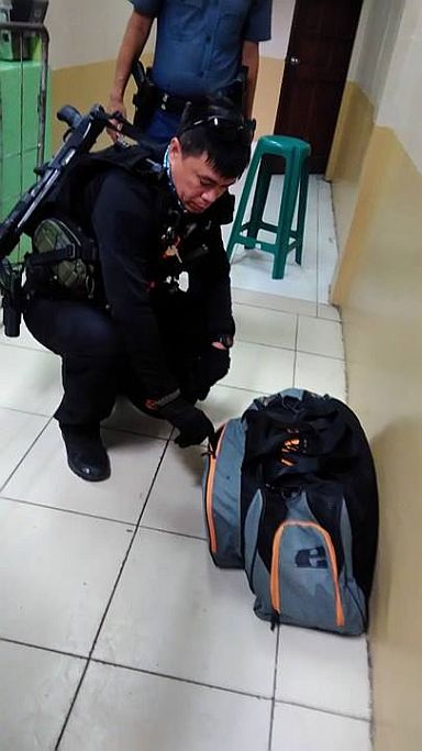 A member of Cebu City Special Weapons and Tactics (SWAT) team checks an unattended bag left in one of the food stall inside Cebu South Bus Terminal (CSBT). (CDN PHOTO/FE MARIE DUMABOC) 