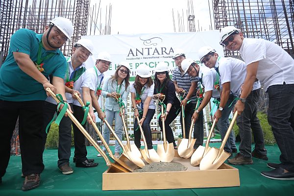 Officials of Nexus Real Estate Corp. shovel cement during the recent topping off ceremony of their Tower 1 Antara project in Talisay City. The project is expected to help Talisay become the “it” destination in Cebu.