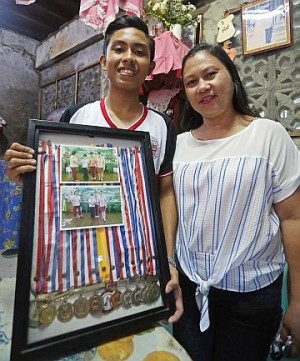 John Franco Saldaña (left) shows the medals he received in school. After learning that he had leukemia, the teenager never gave up, studied hard, kept his hopes alive, and ended victorious in the battle against cancer. (CDN PHOTO/LITO TECSON)
