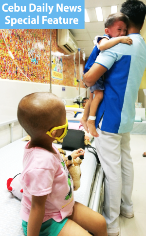 A nurse comforts a boy with leukemia while preparing for a chemotherapy session at the Cebu Doctor's University Hospital's Center for Cancer. (CDN PHOTO/CHRISTIAN MANINGO)