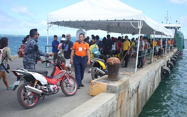 Passengers board one of the Island Shipping vessels, which was given clearance to sail before the Philippine Coast Guard suspended sea trips because of tropical depression Crising. (CDN PHOTO/LITO TECSON)