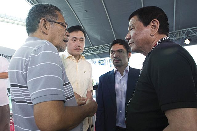 President Rodrigo Duterte discusses matters with former Interior and Local Government secretary Ismael Sueno during a plant launching in Saranggani province. (INQUIRER)