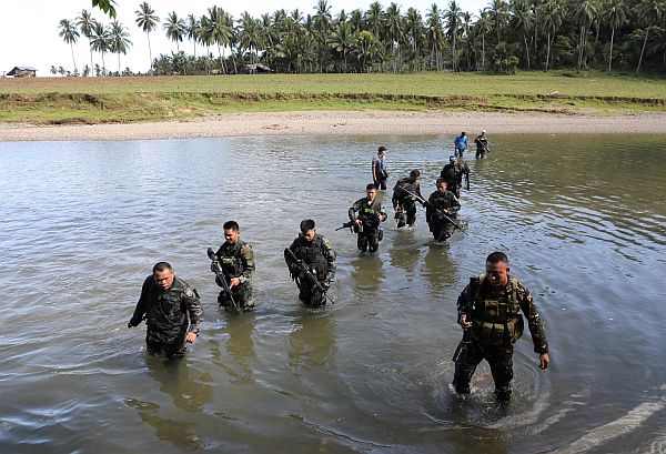 Police forces cross the Inabanga River as they pursue the alleged remaining members of the Abu Sayyaf Group (ABG).   CDN PHOTO/TONEE DESPOJO