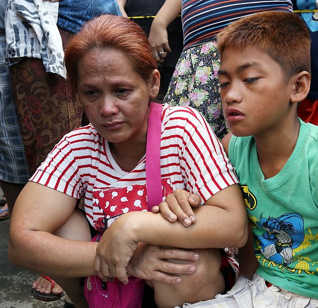Joanry Sumagang and her son shed tears after seeing the remains of Frederick recovered by firefighters at the rubble of their home in Sitio Cabancalan, Barangay Bulacao, Cebu City. (CDN PHOTO/JUNJIE MENDOZA)
