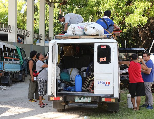  Some of the six “suspicious-looking” men  who were held overnight by  the Oslob police reload their belongings into their van after they were  found to be law-abiding  Muslim traders and were cleared to leave. One of them (back turned, in red) is being interviewed by CDN Senior Reporter Ador Vincent Mayol.  CDN PHOTO/TONEE DESPOJO