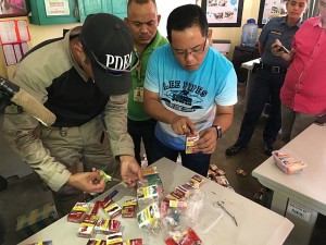 Cebu City Councilor Dave Tumulak, deputy mayor on police matters,  and personnel from the Philippine Drug Enforcement Agency (PDEA) check on the packs of cigarettes intercepted at the grounds of Operation Second Chance Center (OSCC) as the contraband were en route to the nearby Cebu City Jail.  