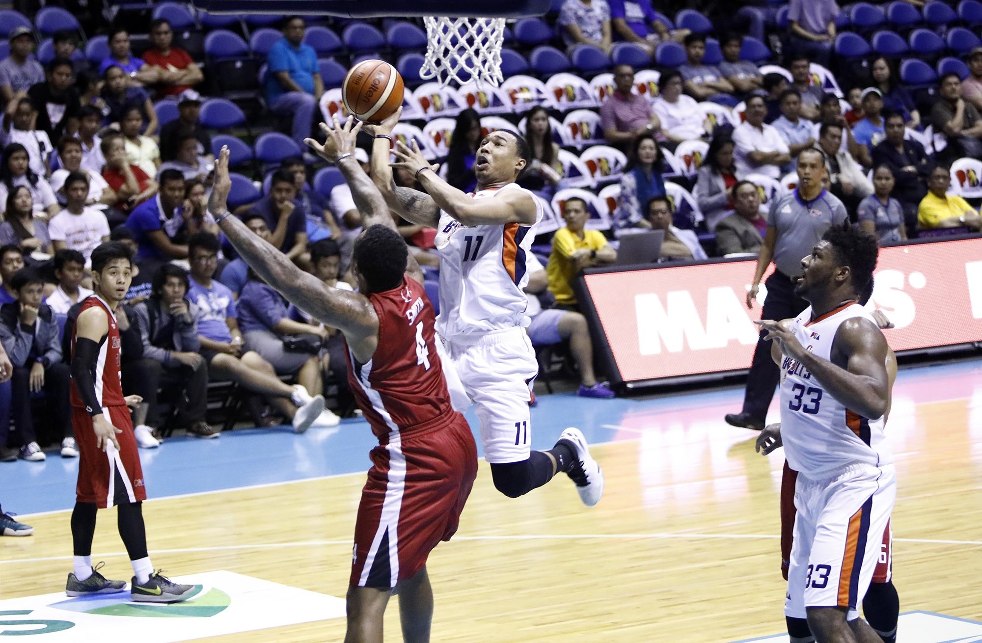 Meralco’s Chris Newsome drives to the basket against Blackwater import Greg Smith in their PBA Commissioner’s Cup game yesterday at the Smart Araneta Coliseum.  PBA IMAGES