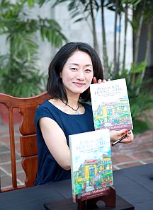 Japanese watercolor artist Dr. Kiyoko Yamaguchi shows a copy of her book.