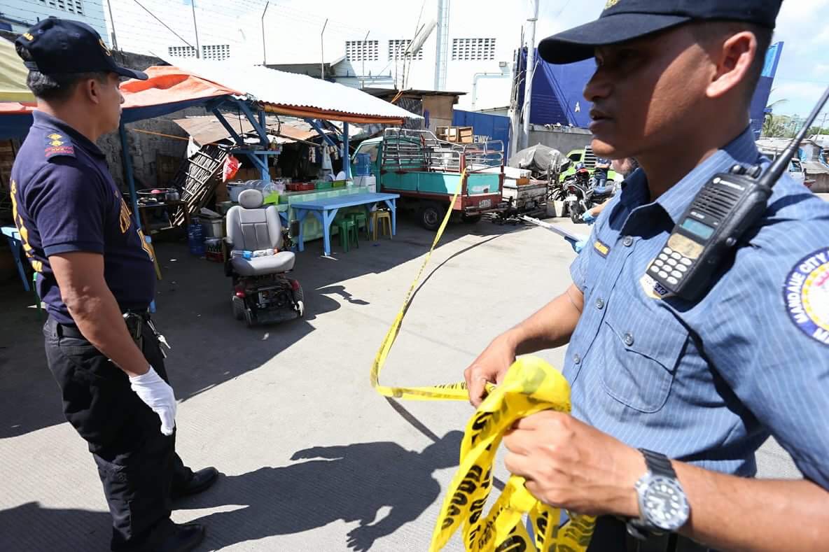 Investigators from the Scene of the Crime Office (SOCO) check the area were Mantuyong barangay captain Antonino Maquilan was shot while seated on his electric wheelchair at Ceniza Street, Mandaue City. (CDN PHOTO/JUNJIE MENDOZA)