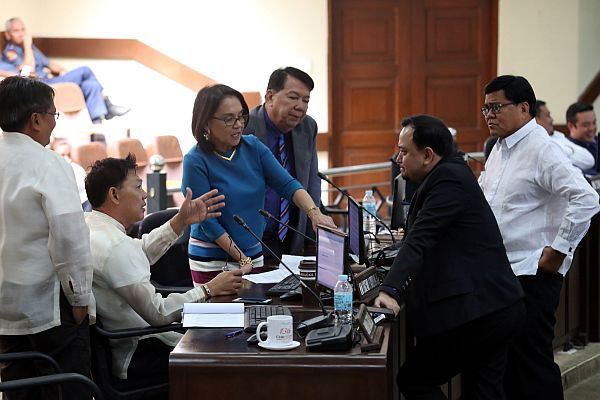 Vice Mayor Edgardo Labella and Councilor Raymond Garcia (right) approach Councilors Eugenio Gabuya (seated) Margot Osmeña, Sisinio Andales and Alvin Arcilla during a one-minute break at yesterday’s session where, once again, the sale of SRP lots was the subject of a discussion. CDN PHOTO/JUNJIE MENDOZA