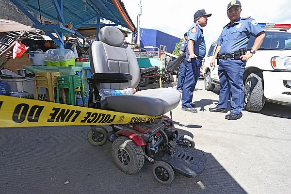  Mandaue City police officers headed by P/Sr. Supt. Roberto Alanas (right) arrive at the crime scene where Mantuyong Barangay Captain Antonio Maquilan, an amputee who moved around in a wheelchair, was gunned down by armed men in bonnets.  CDN PHOTO/JUNJIE MENDOZA