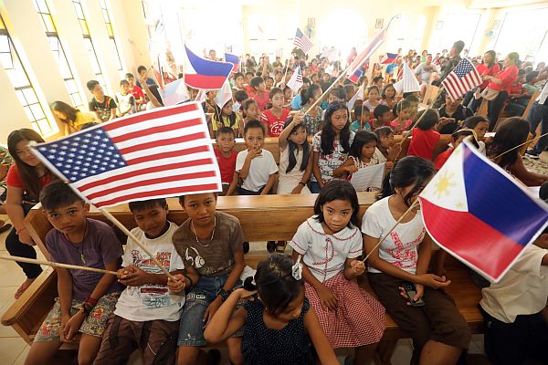Children of Surok Elementary School in Barangay Surok, Guiuan town in Eastern Samar wave Philippine and U.S. flags during a turnover of school supplies from American soldiers which is part of the humanitarian civic activity of the Balikatan 2017 in the province.