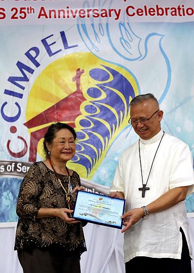 Ms. Marilu B. Chiongbian, C-CIMPEL executive director, receives a lifetime achievement award from Cebu Archbishop Jose Palma during C-CIMPEL’s 25th year anniversary celebration at the  Archbishop’s Residence, Thursday. (CDN PHOTO/JUNJIE MENDOZA)