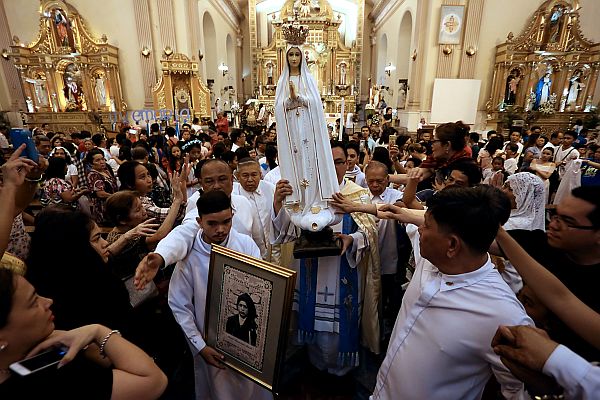 Hundreds of devotees touch the image of Our Lady of Fatima carried by Fr. Erik Orio after the Centennial Mass at the  Cebu Metropolitan Cathedral, which was followed by a penitential procession. Yesterday’s activity celebrated the  100th anniversary of the Our Lady of Fatima apparitions. 