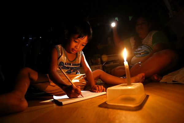 [FILE PHOTO] In 2017, Visayan Electric Company implemented rotational brownouts, prompting students like James Patrick Lumayag, then a kindergarten 2 pupil, to study by candlelight in his house in Barangay Tinago, Cebu City. Today, April 27, 2023, the NGCP announces possible rotational brownouts in the Visayas after the Visayas grid suffered a system disturbance. [CDN FILE PHOTO]