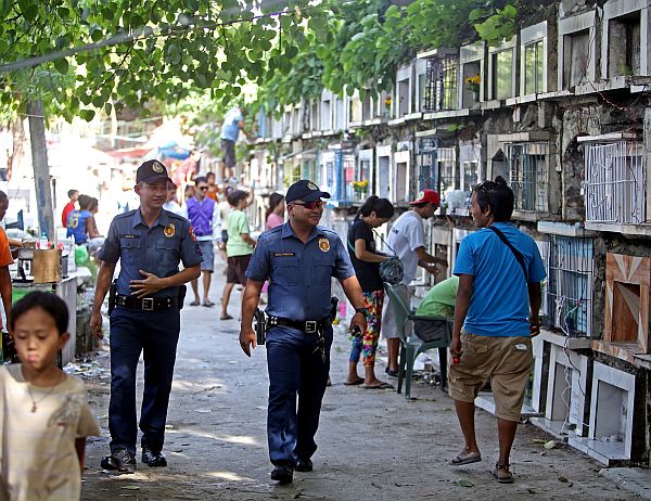 Policemen patrol a cemetery in Cebu City in this 2019 photo. |CDN File Photos