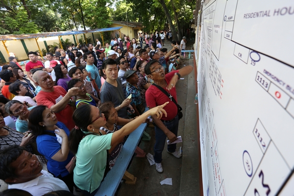 Comelec: Two schools in Cebu City mountain barangays too damaged for polls. In photo are voters looking for their respective precincts outside tarpaulin in front of the Guadalupe Elementary School. | CDN file photo