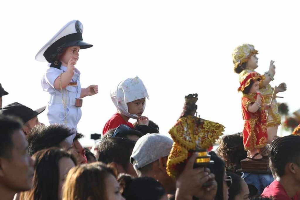 Sto. Niño images are held aloft as devotees wait for the sea procession in Cebu to pass them in this January 2019 photo. | CDN file photo (Junjie Mendoza)