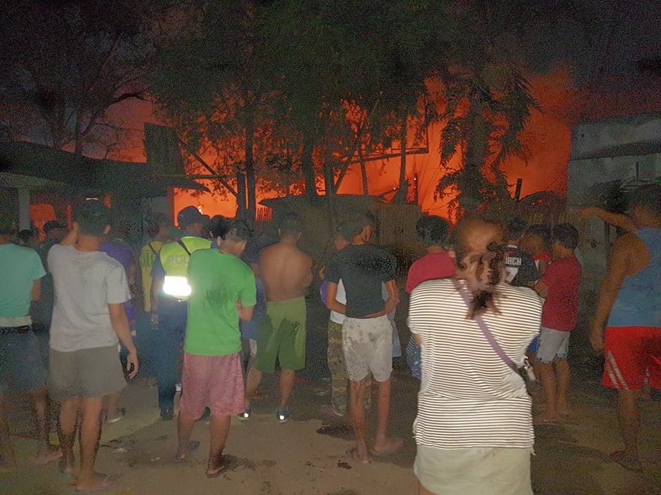 Citizens watch as fire engulfs the homes