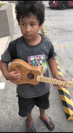 This curly-haired boy, now identified as Jonlie "Tongli" Cabradilla, plays Despacito in his ukelele to customers outside a restaurant near the Mactan Cebu International Airport (MCIA in Lapu-Lapu City. |Photo courtesy of TJ Clemente