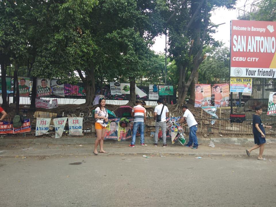 POLICE READY TO SECURE COMELEC PERSONNEL TAKING DOWN ILLEGALLY POSTED CAMPAIGN POSTERS. In photo are Comelec personnel taking down oversized and illegally posted campaign poster in Cebu City in this April 8, 2021 file photo.
