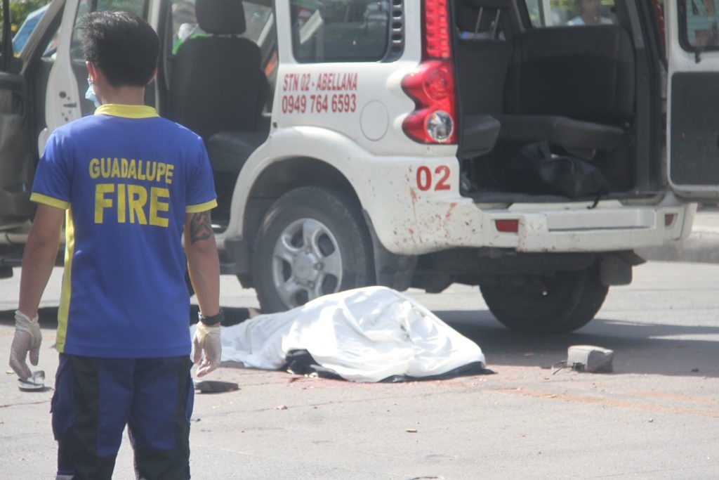 Police cordon the area along M. Velez St., Cebu where Mayor David Navarro (covered in white cloth), was ambushed and killed 