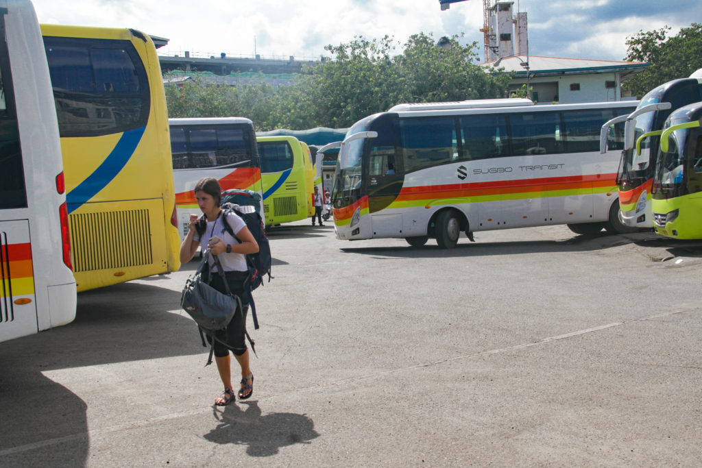 A foreign passenger walks behind parked buses at the Cebu South Bus Terminal located in N. Bacalso Avenue, Cebu City.