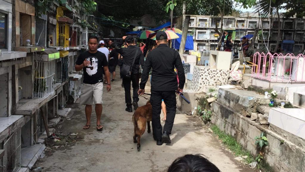 Policemen with a K9 patrol the Calamba cemetery in this November 1, 2019 photo. This year, Cebu City residents can only visit their departed loved ones from September 26 to October 29 because the cemeteries will be closed from October 30 to November 3. | CDN Digital file photo