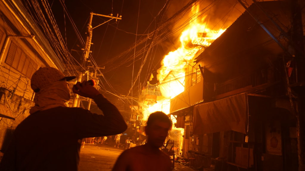 residents checking on burning houses in barangay suba