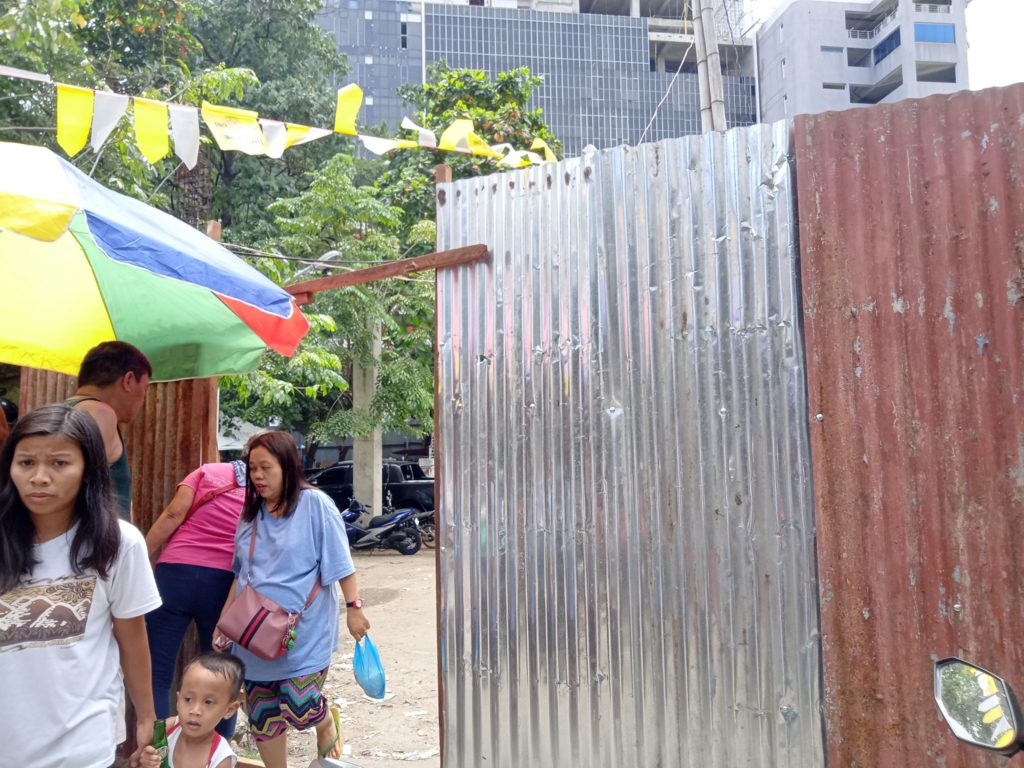 A galvanized iron sheet gate is installed in one of the entry points of the provincial lot in Barangay Luz which is allegedly used as an evacuation site for some of the victims of a fire that hit the barangay last January 13, 2o2o. The Capitol, however, plans to clear the area of structures and settlers because they believe that the fire victims are just used as a front for cockfighting activities there. | CDN Digital file photo