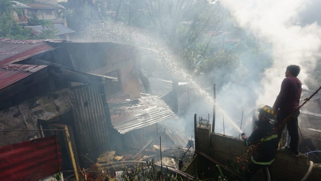 Firefighters continue to spray water to the still smoking houses that have been hit by a March 8 fire in Sitio Bakilid, Lahug, Cebu City. | Gerard Francisco