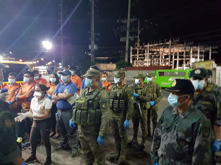 A team of police officers, soldiers and Cebu City Health workers man a thermal scan checkpoint in one of the entry points in Cebu City on the early morning of March 16, 2020. | Alven Marie A. Timtim