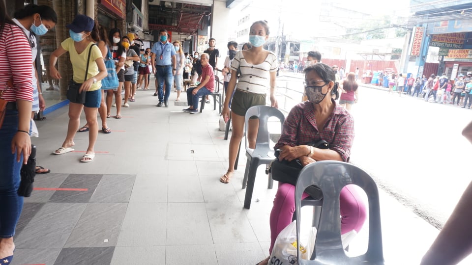A long queue are seen outside a grocery store in Cebu City as people rush to buy supplies after the Cebu province, Cebu City, Lapu-Lapu and Mandaue City have placed their respective areas under a state of enhanced community quarantine. | Gerard Francisco