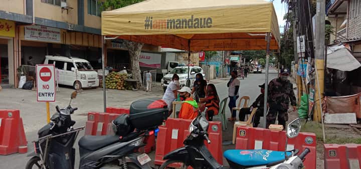 At tent manned by policemen and health workers is seen at the entrance of Burgos Street in Barangay Alang-Alang, Mandaue City, where some 100 households have been placed in quarantine. | Norman Mendoza
