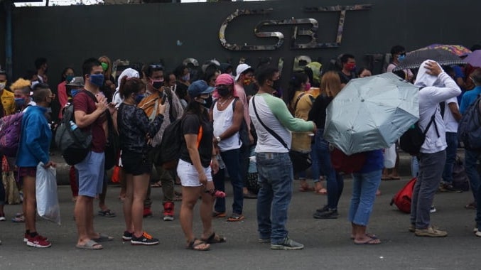 File photo: Passengers line up outside the Cebu South Bus Terminal on Thursday, March 26, 2020, hoping to catch a bus to their respective hometowns. 