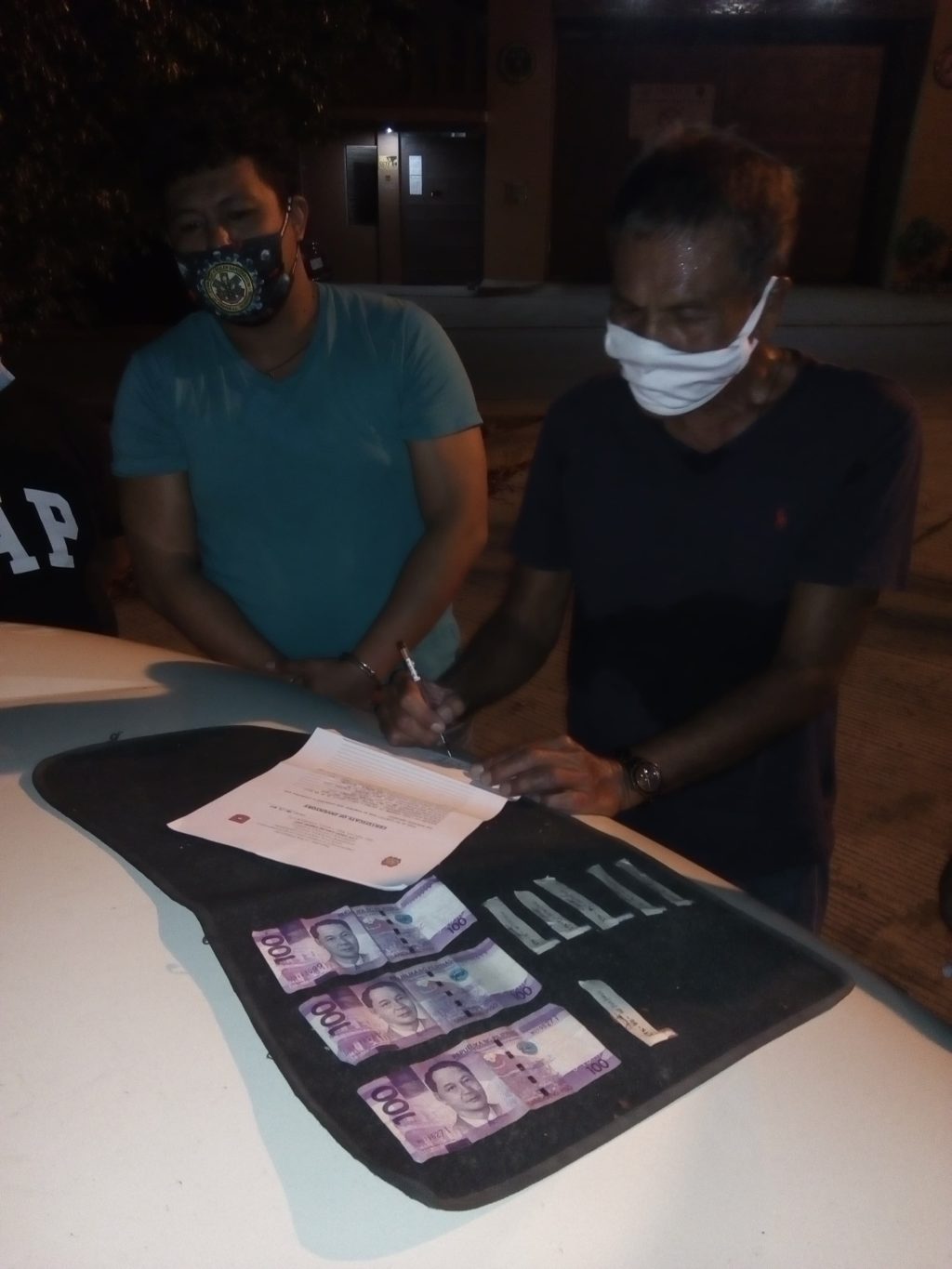 Iphigene Kangleon, a hospital worker, (left) is caught with 6 sachets of suspected shabu during a buy-bust operation in Barangay Jagobiao in Mandaue City at past 8 p.m. on May 2, 2020. |Norman Mendoza