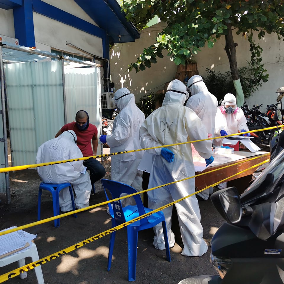 Personnel of the Cebu City Health Department undergo disinfection after collecting swab samples from more than 50 police officers at the San Nicolas Police Station, where two detainees were confirmed to have COVID-19. | Photo courtesy of Councilor Dave Tumulak
