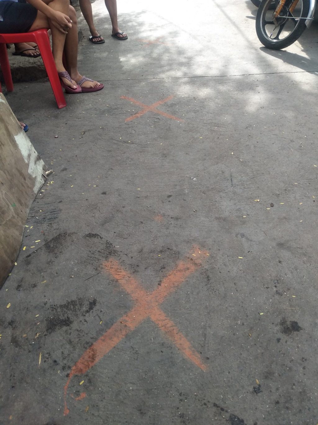 Ghen Camañero of Barangay Tisa, Cebu City makes sure that they will not violate any protocols and draws markers for social distancing for the residents to follow before they can receive the free porridge. | Contributed photo