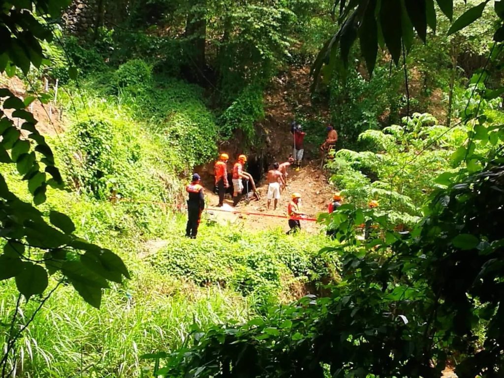 Rescuers try to retrieve the bodies of two men, who were buried after the tunnel they built to extract sand collapsed on Sunday, June 21, in Sitio Ylaya, Barangay Talamban, Cebu City. | Photo courtesy of Paul Lauro