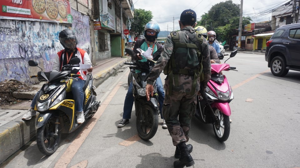 A policeman of the Cebu City Police Office (CCPO) at a checkpoint along V. Rama Avenue in Baranagay Calamba in Cebu City checks motorists for proper travel passes on June 25, 2020, two days since quarantine passes have been suspended. | CDN Digital photo | Gerard Vincent Francisco #CDNDigital