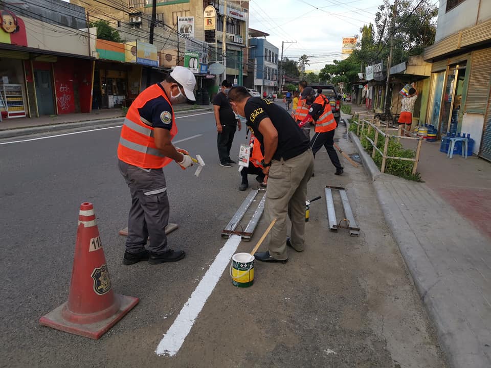 Personnel of the Traffic Enforcement Agency of Mandaue (TEAM) paint markers to identify bike lanes in roads around areas belonging to the city core of Mandaue City in this June 8, 2020 photo.
