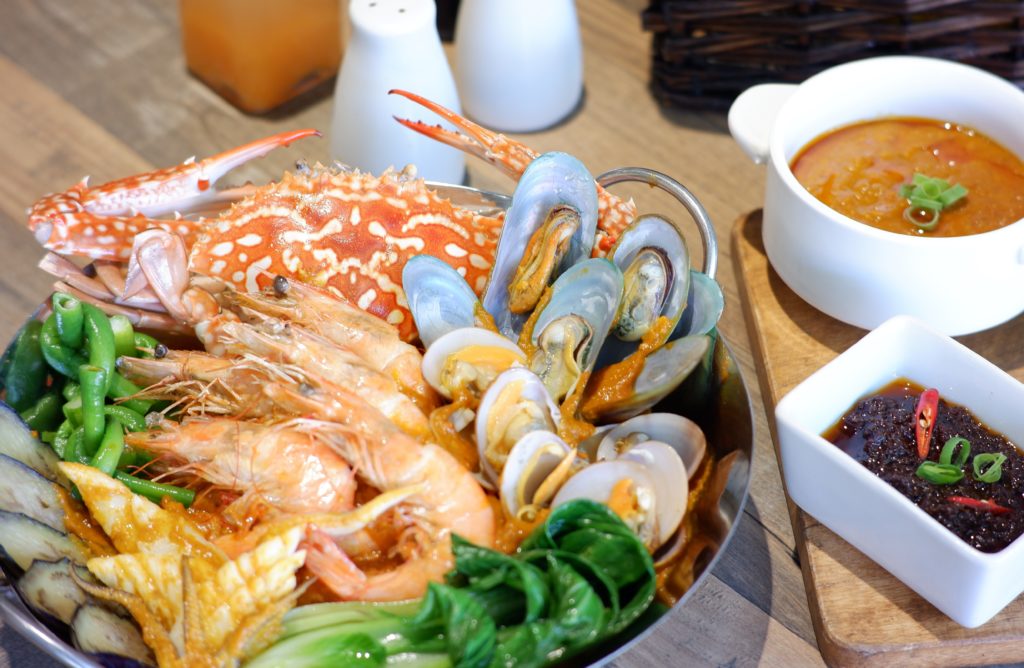 Mixed seafood with shrimps, crabs, mussels with dip and soup on the side.