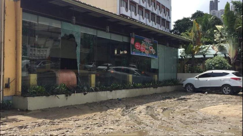 BUS, RESTO, BANKS AND FLOODED STREET. A broken window, mud and water soaked furniture of a restaurant are traces of the damage caused by the wave of floodwater left in the wake of a bus driving through the flooded street in General Maxilom Avenue in Cebu City. | CDN Digital photo by Delta Letigio