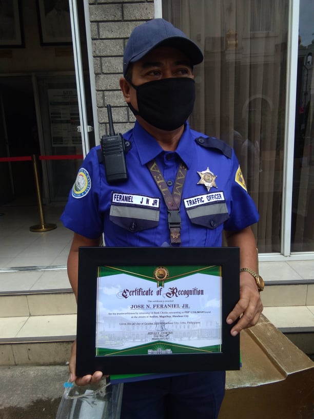 Traffic Enforcer Jose Feraniel receives a plaque of recognition from the Mandaue City government for his honest deed of returning checks worth P1.1 million that he found on the street in Sudlon, Mandaue City on Thursday, October 22. CDN Digital | Mary Rose Sagarino