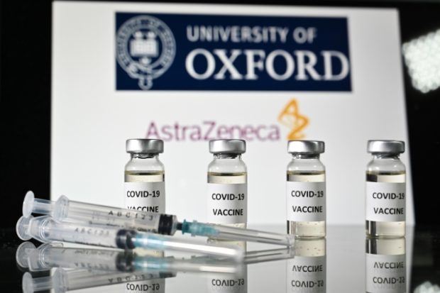 20k doses of AstraZeneca vaccines for Region 7. Four vials labeled COVID-19 vaccine and three syringes are on a table with a  background of a sign saying University of Oxford and AstraZeneca.