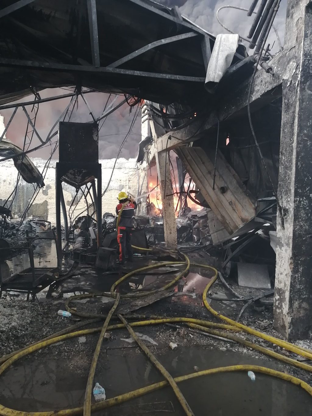 A firefighter continues to put out the fire in a paint warehouse in Barangay Cabancalan, Mandaue City on February 11, 2021. | Contributed photo