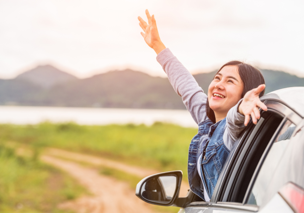 Try the steps to help you cope with challenges -- connect, find meaning and release. Photo shows a smiling woman poking her head and body outside the window of a car with arms outstretched as if welcoming the day with happiness and promise.