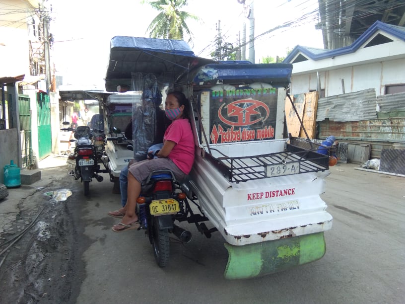 Mandaue City has allowed tricycles to ferry two passengers instead of only one. In photo is a passenger sitting at the back of the motorcycle in Mandaue City. 