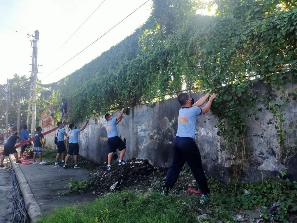 Policemen of the Centro Police Station clean the graffiti on the walls as part of their cleanup drive in Barangay Guizo, Mandaue City.  | Photo Courtesy of Police Major Eric Gingoyon