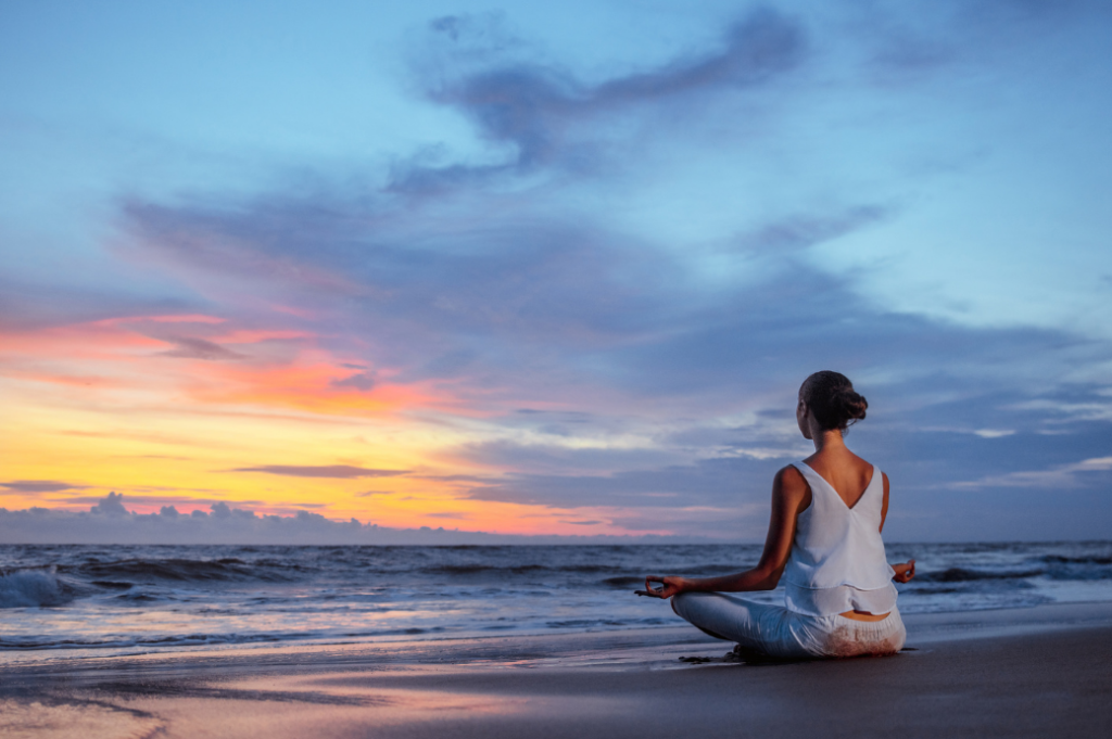 Mantras and meditation. In photo is a woman meditating at the seashore.
